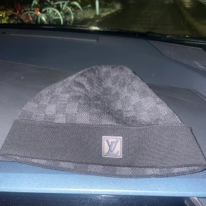 LV mössa - Säljer en fräsch Louise Vuitton mössa som är i väldigt bra skick har knappt använt mössan, mössan har tagit hands om väll. Perfekt för att hålla sig varm med stil under kyliga dagar.
