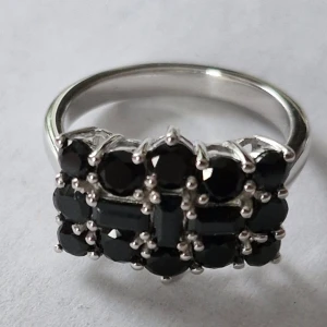 Silverring med svarta spinel stenar - Elegant silverring med flera svarta stenar i en rektangulär design. Ringen är stämplad med 925, vilket indikerar äkta silver. Perfekt för att ge en stilren och sofistikerad look.