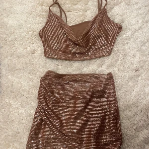 Brunt glittrigt set  - Snygg brun topp och glittrig kjol med paljetter, kjolen har en omlott-design! Perfekt till nyår🎉använt en gång!