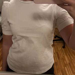 Vit t-shirt - Säljer en klassisk vit t-shirt med korta ärmar. Perfekt basplagg för alla tillfällen. Knappt använd!
