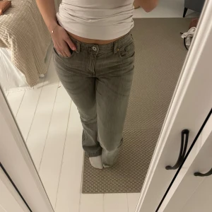 Grå jeans med rosett-detalj - Snygga grå jeans med en unik rosett-detalj på bakfickan. Från H&M barnavdelning storlek 164 i längden. Man kan reglera storleken runt midjan. 