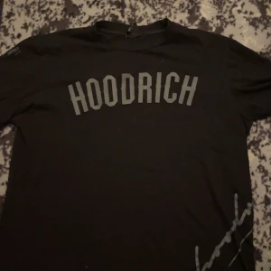 Svart t-shirt från Hoodrich - Snygg svart t-shirt från Hoodrich med tryck 'HOODRICH' på framsidan och 'FROM NOTHING TO SOMETHING' på baksidan. Perfekt för en casual look.