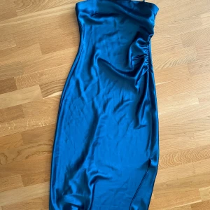 Blå satinklänning  - Grönblå satinklänning i bandeau modell