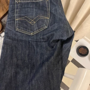 Mörkblå jeans från Replay - Säljer ett par snygga mörkblå jeans från Replay. De har en klassisk femficksdesign med coola sömmar på bakfickorna. Jeansen är i storlek 31/34 och passar perfekt för en avslappnad stil. Perfekta för både vardag och fest! Pris kan diskuteras 