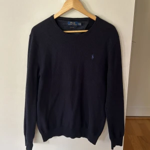 Stickad Ralph Lauren tröja - Mörkblå stickad Ralph lauren tröja. Inga deffekter. Den är lite stor i storleken så mellan S-M