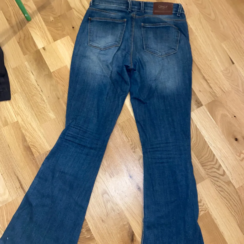 Säljer ett par blå bootcut jeans från ONLY. De är low waist och har hål vid knäna. Det är i storlek 29 som motsvarar S/M, de passar mig som har M på jeans. Inga defekter💙. Jeans & Byxor.