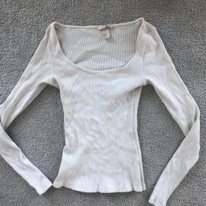 Vit ribbad topp - Säljer en superfin vit ribbad topp med långärmad design. Den har en snygg, tight passform och är perfekt för både vardag och fest. Toppen är i storlek S och är i nyskick🩷