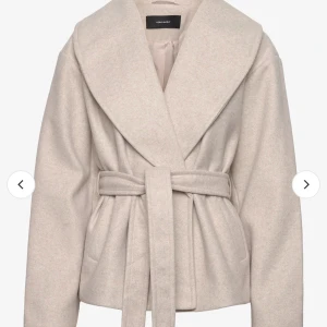 Beige kappa från Vero Moda - Säljer en superfin beige kappa från Vero Moda. Den har en snygg omlott-design med ett bälte i midjan som ger en elegant look. Perfekt för höst och vår! Den är långärmad och gjord i ett mjukt material som känns lyxigt.