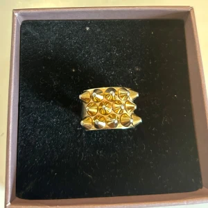 Edblad ring - En fin och trendig ring i guld. Den har 18.5mm i diameter. Topparna på piggarna är lite slitna men inget man märker tydligt. 