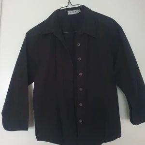 Svart skjorta från Vila - Säljer en stilren svart skjorta från Vila. Den har korta ärmar och knappar framtill. Perfekt till vardag.