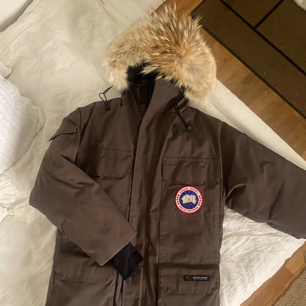 Canada Goose Expedition Parka mörkgrön i unisex stl XXS / 2XS (stora storlekar).  Jackan är som ny och i jättefint skick i enlighet med bilderna.   Nypris på Canada Goose hemsida idag 23 300sek. (Ena mudden har några trådar som lossnat, inget stort).. Jackor.