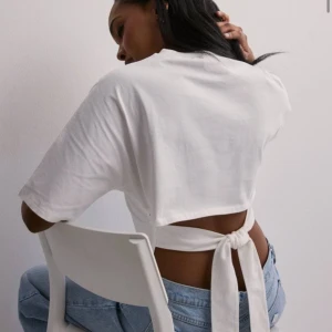 open back tie tee - Otroligt fin topp från nelly. Har fått två små ränder på grund av smink, borde gå att få bort. Säljer eftersom som den ej kommer till användning. Helt slutsåld i storlekarna, xxs, xs och s🩷