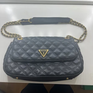 Guess väska - Jättefin Guess väska! Kvalitén är bra och den har inga defekter. Köpt i butik för ca 1 år sedan, väskan går att hitta på deras hemsida för 1 600kr