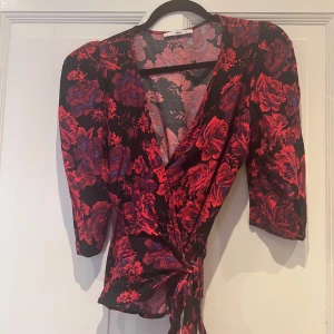 Blommig omlottblus - Super snygg & kurv framhävande blus med lite puffiga axlar, trekvart ärmar & knyt i midjan. 