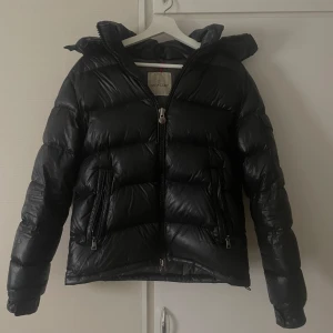 Moncler Maya  - Säljer min Moncler maya då jag är sugen på något annat till vintern, har en lagning på ryggen längst ner men inget man tänker på när man väl har den på (vad jag märkt i min ägo) annars är den helt felfri (hade inte lagning varit där så är den 10/10 