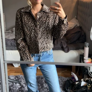 Leopardjacka/ skinnjacka  - En jacka som man kan byta håll på samt knappar på båda sidorna. Ena sidan är leopard mönstrad och andra skinn
