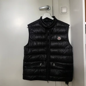 Moncler gui väst - Säljer min svarta moncler gui i TG3/storlek 3 vilket motsvarar storlek M. Köpt från haiendoshop och kvitto finns. Toppen skick, inga skador eller skavanker. Riktigt schysst väst nu till våren/sommaren! 