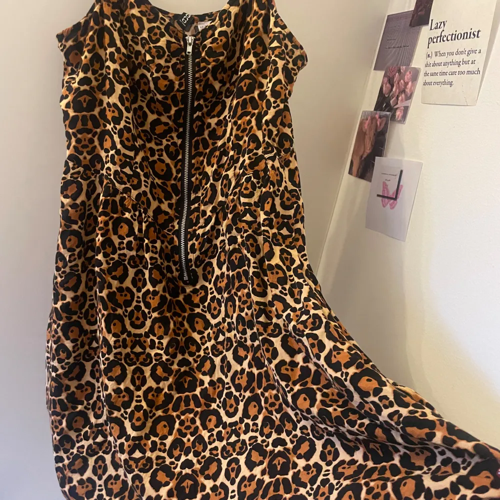 Säljer en supercool leopardmönstrad klänning från H&M. Den har en dragkedja framtill och är ärmlös, vilket gör den perfekt för en fest eller en utekväll. Klänningen är i storlek 38 och har en normal passform. Materialet känns lätt och bekvämt, perfekt för att dansa hela natten! 🐆✨. Klänningar.