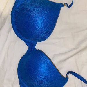 Blå bikiniöverdel från Victoria's Secret - Säljer en snygg blå Bh från Victoria's Secret. Den har en glansig yta med ett subtilt mönster och justerbara axelband. Inga defekter, endast använd 2 gånger💗