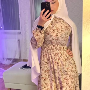 Blommig långklänning - Säljer en superfin blommig långklänning i ljusa toner. Klänningen har långa ärmar och ett elastiskt band i midjan 🌸🌷