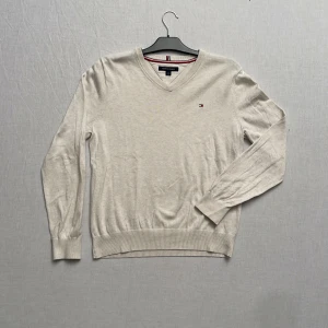 Beige crewneck från Tommy Hilfiger - Säljer en stilren beige tröja från Tommy Hilfiger i storlek S. Perfekt för både vardag och lite finare tillfällen. Tröjan är i bra skick och har inga defekter. Skriv vid frågor!