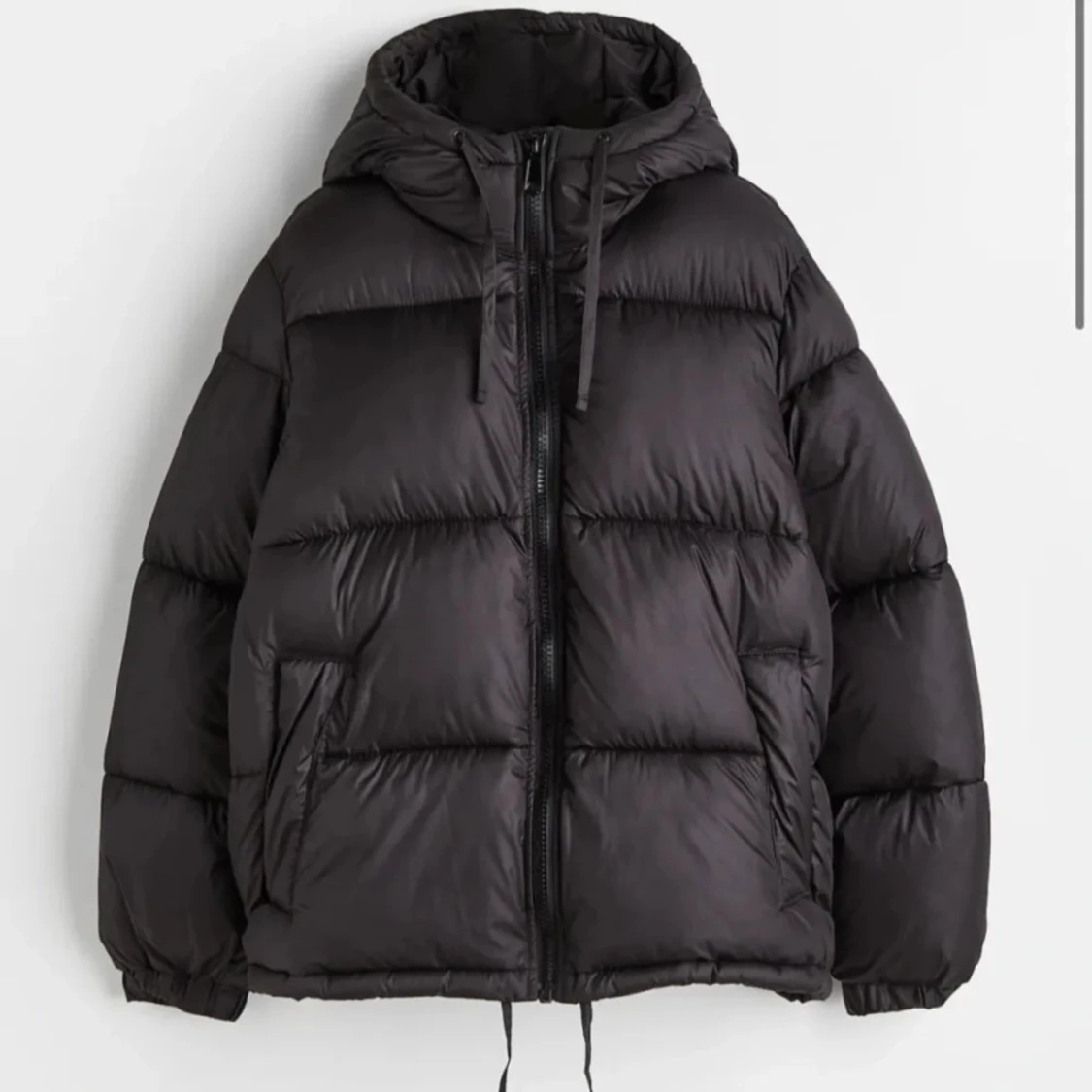 Svart pufferjacka med huva