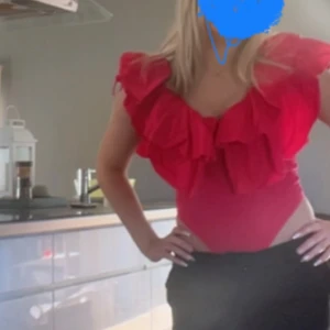 volangbody - Säljer en superfin röd rosa volangtopp med stora volanger över axlarna. Toppen är tight och perfekt för festliga tillfällen.