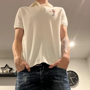 Ralph lauren pike  - Säljer en snygg vit pikétröja från Polo med en broderad logga på bröstet och en stor broderad polospelare på ryggen. Tröjan har  en klassisk krage. Perfekt för en avslappnad men stilren look. Passar både till vardags och lite finare tillfällen.