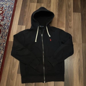 Svart hoodie från Polo Ralph Lauren - Säljer en snygg svart hoodie från Polo Ralph Lauren i storlek S. Perfekt för höst och vinter med sin mysiga fleeceinsida. Lite solblekt men de inget man märker från långt. Skulle säga att den passar för dom som e runt 160-170 perfekt 🤩 Skick 7/10
