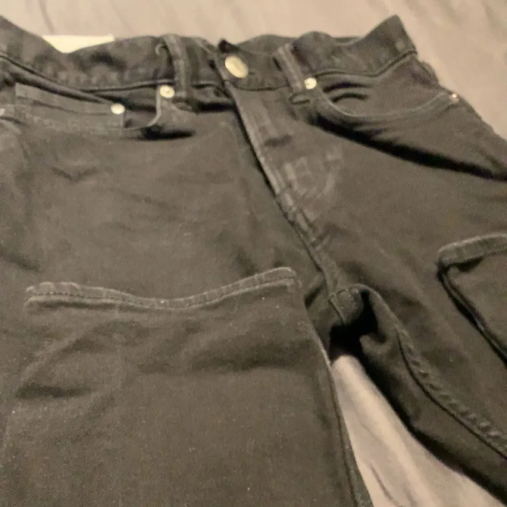 Säljer ett par svarta slim fit jeans från H&M i storlek 30/32. De är i bra skick och har en klassisk femficksdesign med knapp och dragkedja framtill. Perfekta för både vardag och fest!. Jeans & Byxor.