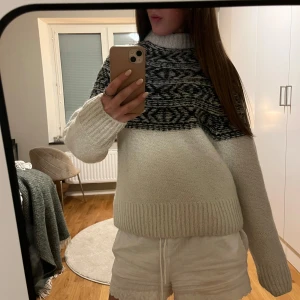 Vit och svart stickad tröja från H&M - Mysig vit stickad tröja från H&M med ett snyggt svart mönster upptill. Perfekt för kyliga dagar med sin varma och bekväma passform. Tröjan har långa ärmar och ribbade kanter. Passar både till vardags och mysiga hemmakvällar. 🖤🤍(defekt finns, se sista bilden)