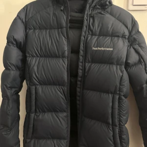 Mörkblå dunjacka från Peak Performance - Säljer en mörkblå dunjacka från Peak Performance i storlek XS. Är välanvänd men inget som syns då den är i jätte fint skick! Köpte för 4200kr