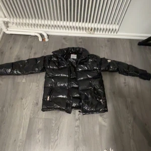 Moncler jacka  - Säljer en snygg svart pufferjacka från Moncler i mycket bra skick. Fick den i födelsedagspresent och den är liten. Jackan är perfekt för vintern med sitt quiltade mönster och långa ärmar. Den har en dragkedja framtill och Monclers ikoniska logga på ärmen. Supervarm och stilren för kalla dagar! Storlek M på jackan, jackan är dessutom utan luva.