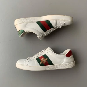 Gucci Ace Sneakers - Riktigt fina Gucci Ace sneakers, bra skick förutom en spricka och en söm som gått upp lite vid ankeln på vänstra skon. Skulle säga 7/10, inget og. Skriv för fler bilder eller vid funderingar 😁🙌