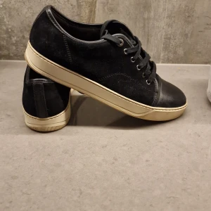 Lanvin cap toe - Snygga och välbehållna sneakers i svart mocka och läder cap. Tyget i toppskick 8.5 av 10. Storlek 8 (42/43).  Ingen låda medföljer, för små därav säljs dom. Inga byten. Fler bilder kan skickas