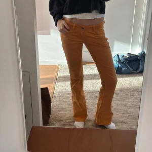 Gula bootcut byxor - Säljer ett par snygga gula bootcut byxor i mycket bra skick. De är lågmidjade och är Perfekta för höst och vår, och ger en härlig färgklick till din garderob! Midjemått 37cm innerbenslängd 79 cm