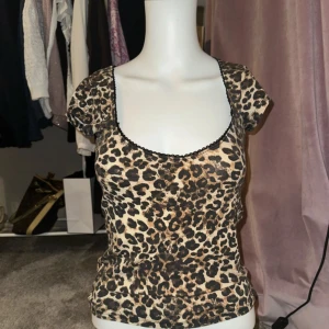 Leopardmönstrad topp från Nelly - Säljer en supercool leopardmönstrad topp från Nelly i storlek S. Toppen har korta ärmar och en tight passform som framhäver figuren. Perfekt för en utekväll eller fest! 🐆✨