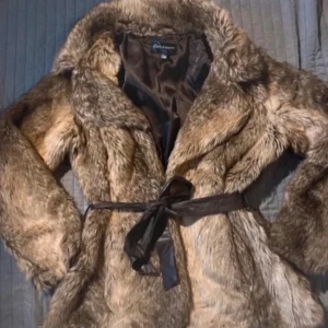 pälsjacka - Supermysig brun pälsjacka!! Perfekt för att hålla sig varm och snygg under höst och vinter, väldigt varm och skön. Jackan har en lyxig känsla och passar perfekt till både vardag och fest!! Har aldrig använt den utomhus, endast testat den, helt perfekt nyskick. 