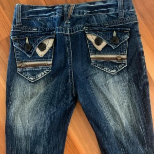 Lågmidjade bootcut jeans med coola fickor - Unika Lågmidjade jeans som är jättebekväma och passar M, de kan också passa s med mer lose fit så som de sitter på mig.  Innerbenslängd: 74 cm Ytterbenslängd: 97 cm Midjemått: 38 x2 cm