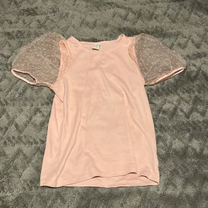 Rosa topp med puffärmar från Lindex - Säljer en superfin rosa topp från Lindex med puffiga, prickiga ärmar i ett transparent material. Perfekt för både vardag och fest! Toppen är i mycket bra skick och passar barn i åldern 10-12 år. 🌸Kontakta mig om frågor & fler bilder🩷Pris kan diskuteras!!