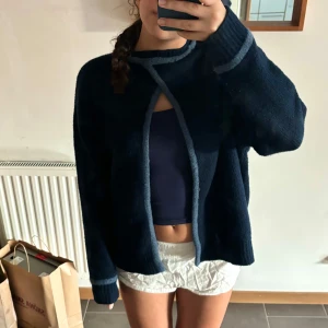 Mörkblå stickad tröja - Säljer en supermysig mörkblå stickad tröja med en unik öppen ryggdetalj i nyskick. Perfekt för höst och vinter! Den kan även vändas om för att ha den som en kofta. Tröjan har långa ärmar och en loose passform som gör den extra bekväm❤️❤️❤️säljer pga den aldrig används, pris går såklart att diskutera ❤️