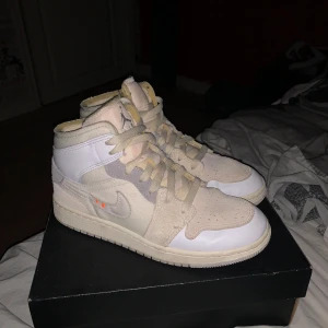 Nike Air Jordans i beige och vit - Säljer ett par Nike Air Jordans i beige och vit. De är i mycket bra skick och kommer i originalkartong. Perfekta för både vardag och fest med sin stilrena design och bekväma passform. Skorna har snörning och en klassisk Air Jordan-logga på sidan.