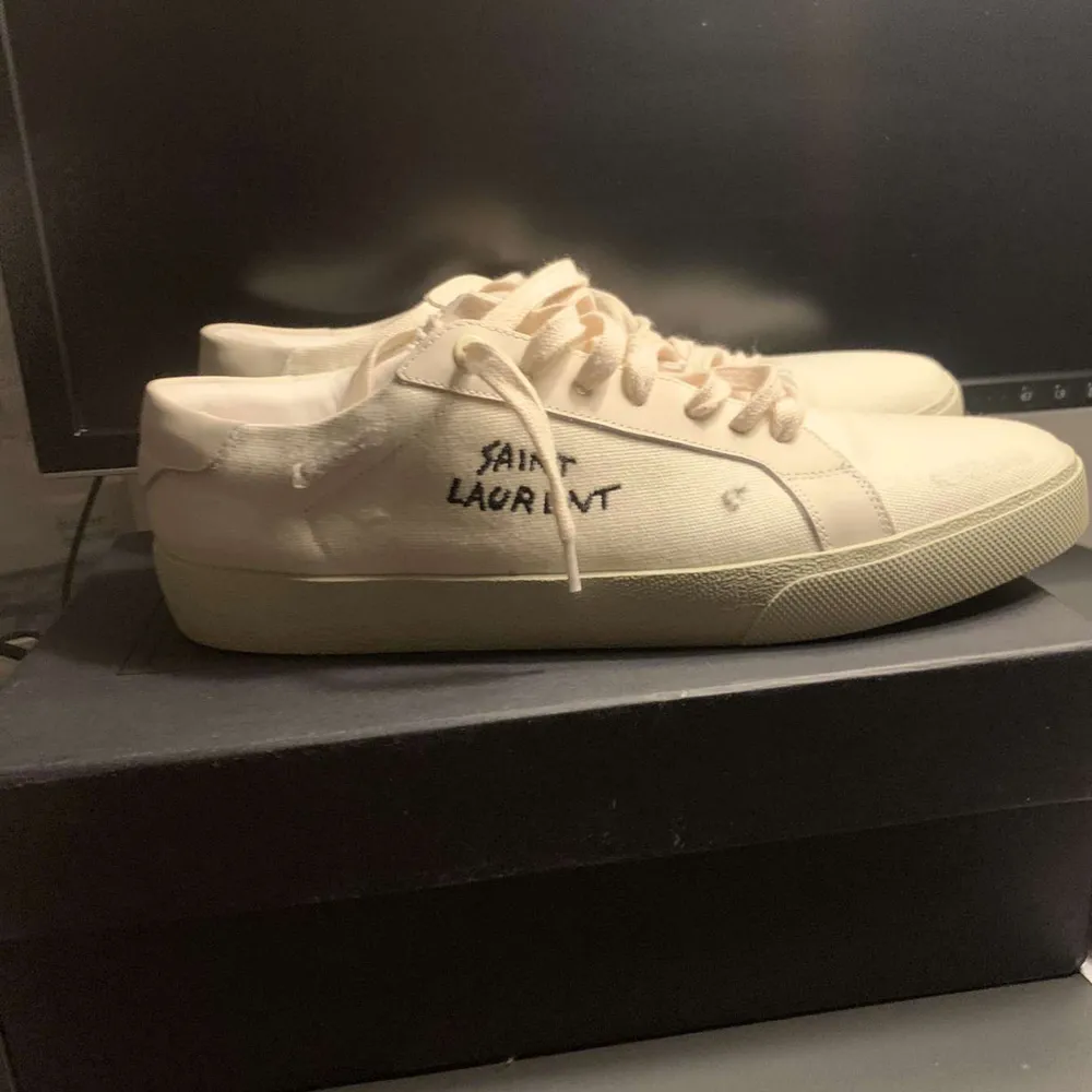 Säljer ett par stilrena vita sneakers från Saint Laurent. De har en klassisk design med snörning och är i mycket bra skick. Perfekta för både vardag och fest. Kommer med originalkartong.. Skor.