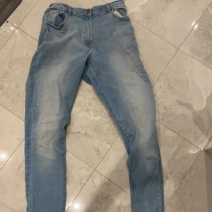 Blå jeansbyxor - Säljer ett par klassiska blå jeansbyxor i bra skick. De har en normal passform och är perfekta för vardagsbruk. Byxorna har en dragkedja och knappar framtill. Perfekta för både vår och höst!