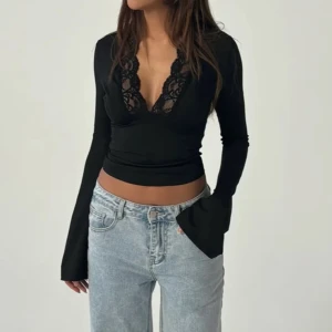 Svart långärmad topp med spetsdetaljer - Snygg svart långärmad topp med  v-ringning och spetsdetaljer. Helt ny, oanvänd. Från Niventina 