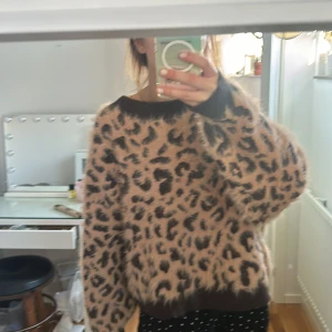 Leopardmönstrad fluffig tröja - Supermysig och fluffig tröja med leopardmönster. Perfekt för att hålla sig varm och stilren under kyliga dagar. Tröjan har en loose passform och långa ärmar, vilket gör den både bekväm och trendig. Ett måste för höstgarderoben! ❤️NYSKICK!!