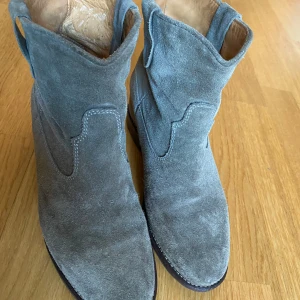 Isabel Marant mockaboots - Säljer ett par snygga mossgröna mockaboots från Isabel Marant i storlek 39. De har en klassisk design med en robust sula och är perfekta för höst och vår. Bootsens stilrena look gör dem lätta att matcha med olika outfits. Använda men i bra skick, nysulade.