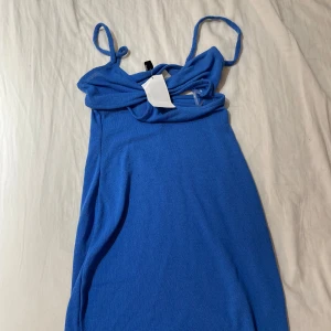 Blå klänning från hm - Säljer en snygg blå klänning från Divided i storlek XXS. Den har smala axelband och en stilren design, perfekt för sommarens fester. Klänningen är i ett mjukt och bekvämt material som känns skönt mot huden.