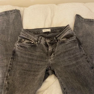 Lowwaist bootcut jeans - Säljer ett par snygga grå/svarta jeans från Gina Tricot. Dom är lowwaist bootcut. Dom är i bra skick och är i storlek 32. Nypris 499