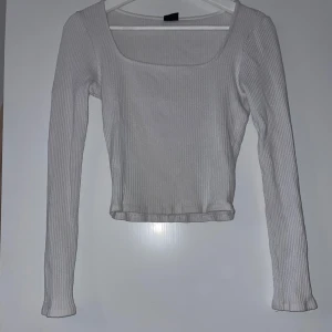 Vit ribbad långärmad tröja - Säljer en stilren vit ribbad tröja med långa ärmar. Tröjan har en tight passform och är superbekväm. Den är i  bra skick och passar perfekt till jeans eller kjol. Ett måste i garderoben!